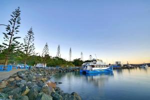 een boot ligt aangemeerd in een rivier met rotsen bij Breathtaking Clifftop Ocean Views from Unit 12 in Eden