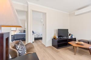 een woonkamer met een bed en een kamer met een tv bij Breathtaking Clifftop Ocean Views from Unit 12 in Eden