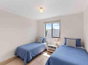 een slaapkamer met twee bedden en een raam bij Breathtaking Clifftop Ocean Views from Unit 12 in Eden +21 foto's