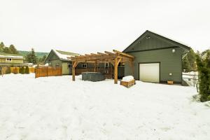 a backyard with a building in the snow at Mountain Retreat with Hot Tub, Game Room and Yard home in Ronald