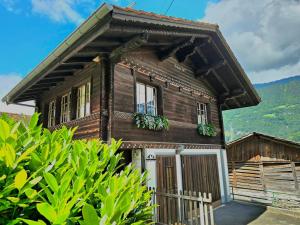 a small wooden house with a porch at Mountain Homes - Outpost Studio in Bönigen