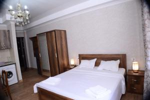 a bedroom with a bed with white sheets and a chandelier at Dreamy Hotel in Ureki