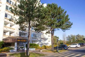 two trees in a parking lot in front of a building at Atlantic 209 in Döse
