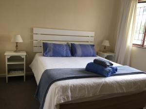 a bedroom with a large bed with blue pillows at Petes Beach House in Port Shepstone