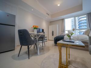 a kitchen and living room with a table and chairs at Dunya tower suite 2 in Dubai
