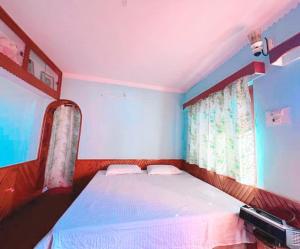 a small bedroom with a bed with a window at Kamal Homestay in Nainital +8 photos