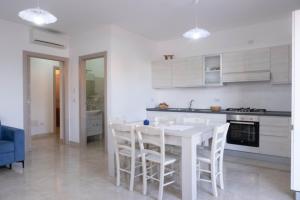 a white kitchen with a white table and chairs at Guest House in Mercatello