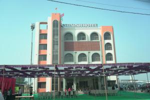 阿南德Adarsh Hotel的一座大楼，前面站着一些人