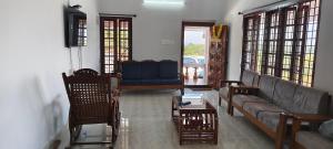 a living room with a couch and a table and chairs at The Whitehouse Homestay in Manipal