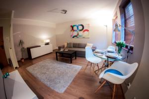 - un salon avec une table, des chaises et un canapé dans l'établissement Apartament Karlikowska, à Sopot