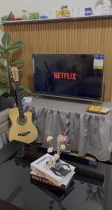 a guitar sitting on a table next to a tv at Jungle Escape in Manila