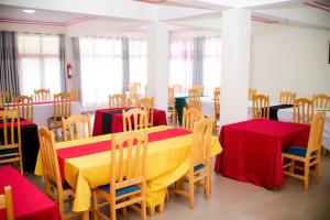 a dining room with red and yellow tables and chairs at CENTRE PASTORAL SAINT AUGUSTIN RWAMAGANA in Rwamagana