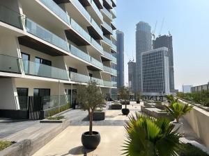 a building with a courtyard with trees and buildings at Binghatti canal suites smart home by kings holiday in Dubai