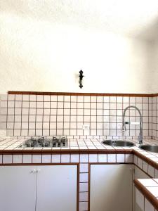 a kitchen with two sinks and a tiled counter at Sa Maluni in Geremeas +23 photos
