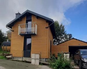 a wooden house with a balcony on top of it at CHALET COSY A LA MONTAGNE AVEC SAUNA TONNEAU situé à St Laurent en Grandvaux - Proche lacs cascades et pistes de ski in Saint-Laurent-en-Grandvaux