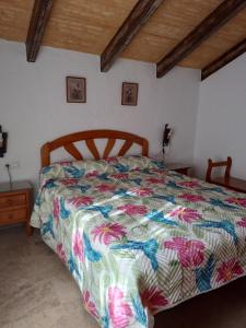 a bedroom with a bed with a colorful comforter at Entre Pinos in El Palmar