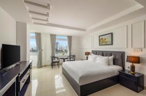 a hotel room with a bed and a television at Kay Han Riverfront Hotel Da Nang in Danang