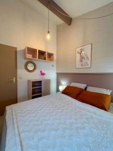une chambre avec un grand lit blanc avec des oreillers orange dans l'établissement CASA Chill I Port & Plage à 500 m I Parking Privé, au Barcarès 38 autres photos