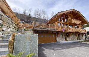 uma grande casa de madeira com uma grande garagem em Chalet Grand Area em Briançon