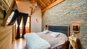 a bedroom with a brick wall and a bed at Chalet Grand Area in Briançon