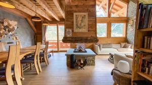 a living room with a table and a fireplace at Chalet Grand Area in Briançon
