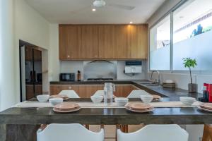 チャングーにある5BR Private Pool Villa - 1 min Beach - Daily Staff, Private Pool, Gym & Gamesのキッチン(テーブル、白い椅子付)