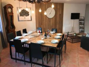 een eetkamer met een tafel met stoelen en een klok bij La Roselière in Mérindol