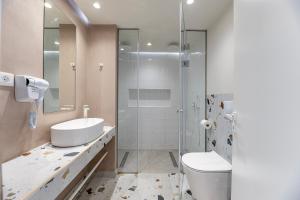 Un baño con ducha, inodoro y lavabo. en Akti Coast Club, en Marmari