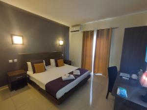 斯利马The Windsor Hotel的配有床和书桌的酒店房间