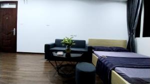 a room with two beds and a table with a plant at 18 ngõ 154 Đình Thôn in Hanoi