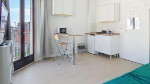 a kitchen with a counter and a table with a microwave at L'opale, studette 4 in Berck-sur-Mer