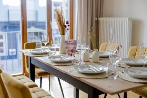 慕尼黑Lumen Homes - Altstadt-Residenz, direkt im Zentrum, geräumiges Apartment mit 5 Zimmern, Küche的一张木桌，上面放着盘子和玻璃杯 更多75张照片