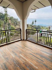 un balcón vacío con vistas a la montaña en Isha Villa, en Pālampur