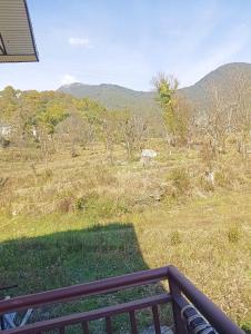 Un balcón con vista a un campo y montañas. en Isha Villa, en Pālampur