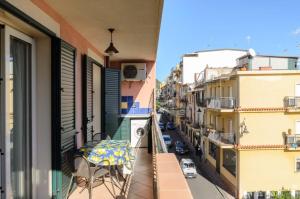 a balcony with a table and chairs on a city street at Le Tartarughe Aparthotel in Letojanni