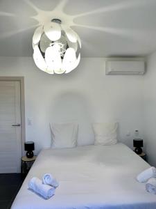 a bedroom with a white bed with towels on it at 9D - appartement Bonifacio Corse in Bonifacio +17 photos