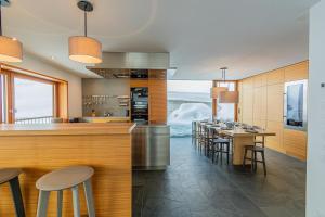 a kitchen with a bar and tables and chairs at Luxury Panorama Apartment Tola in Saas-Fee