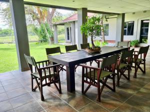 a dining room table and chairs on a patio at Riverise Guesthouse in Maun