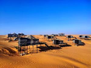 a group of huts in the middle of the desert at Moon Light Luxury Camp in Badīyah