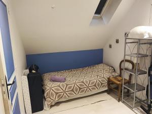 a small bedroom with a bed and a shelf at Quiétude Vexinoise in Boury-en-Vexin