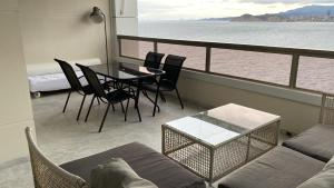 a living room with a table and chairs on a balcony at Excellent apartment in front of the sea! in Benidorm