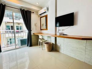 a living room with a bar with a flat screen tv at PJ Patong Resortel in Patong Beach