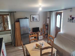 a living room with a table and a refrigerator at Quiétude Vexinoise in Boury-en-Vexin