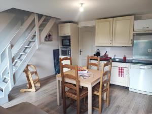 a kitchen with a table and chairs and a staircase at Quiétude Vexinoise in Boury-en-Vexin
