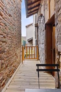 a wooden walkway with a bench in front of a brick building at Les chambres Tonics in Montrevel-en-Bresse