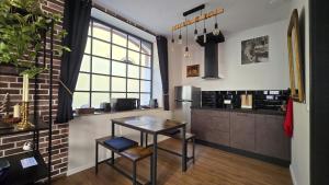 a kitchen with a table and a table and a window at L'Atelier de l'Arc in Saverne