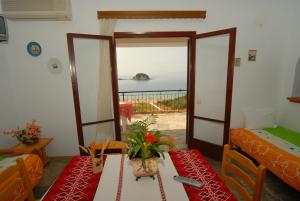 a room with a table and a room with a view of the ocean at Villa Matina Skiathos in Troulos