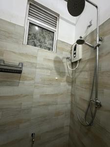 a shower stall in a bathroom with a window at Nomad House in Kandana