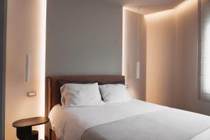 a bedroom with a white bed with a table and a window at Thissio Acropolis Historic Flat 1 in Athens