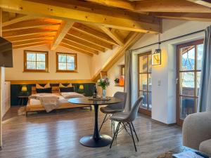 een slaapkamer met een bed, een tafel en stoelen bij Haus Kilian in Berchtesgaden +28 foto's